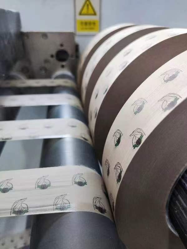 Rolling paper manufacturing process with large paper rolls and industrial production equipment in a factory